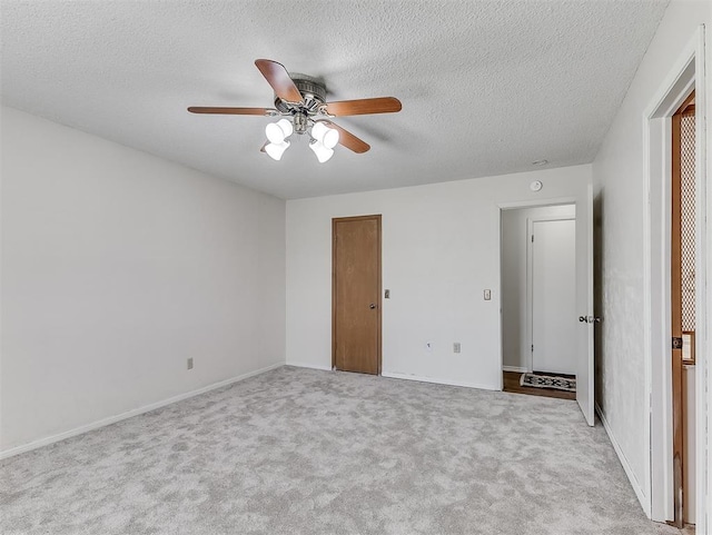 unfurnished bedroom featuring ceiling fan, light carpet, and a textured ceiling