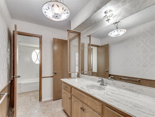 bathroom with vanity, shower / tub combination, and a textured ceiling