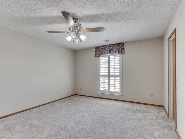 unfurnished bedroom featuring light colored carpet, a textured ceiling, and ceiling fan