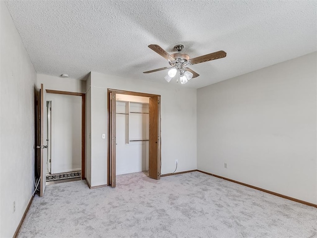 unfurnished bedroom featuring a textured ceiling, light colored carpet, and ceiling fan