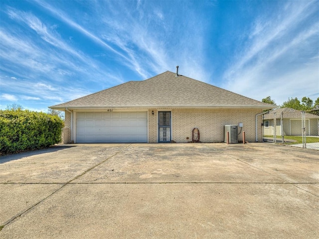 view of front of home featuring a garage and central AC unit