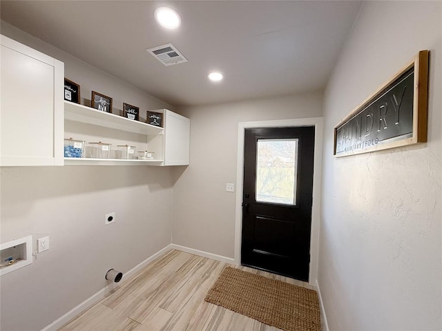 washroom with hookup for an electric dryer, cabinets, washer hookup, and light hardwood / wood-style floors