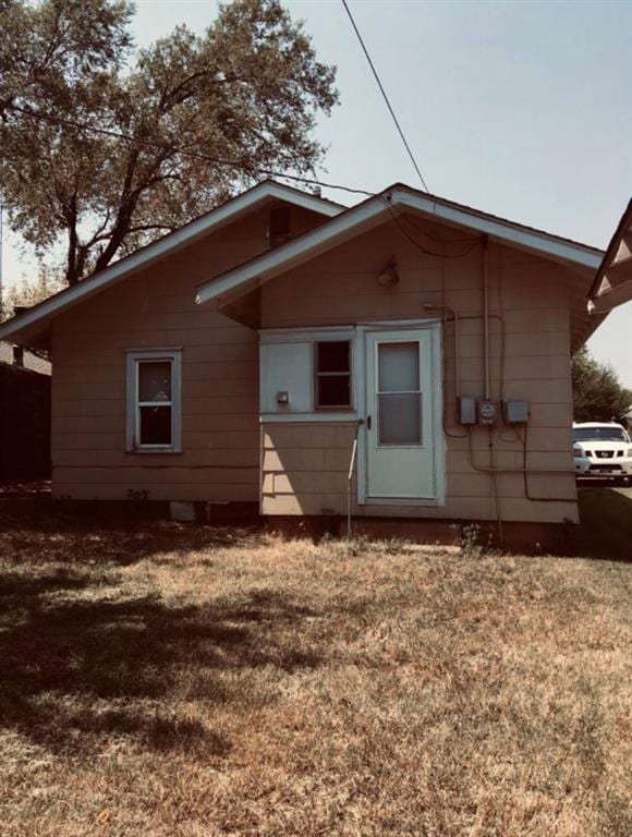 back of property featuring a lawn