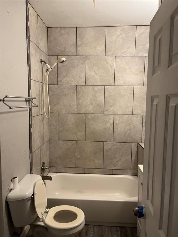 full bathroom with vanity, tiled shower / bath, hardwood / wood-style flooring, and toilet