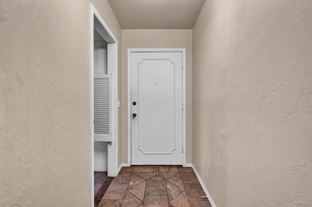 doorway to outside with dark tile patterned flooring