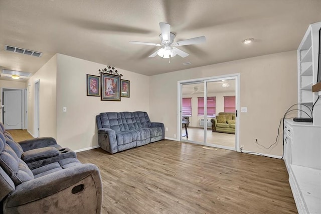 living room featuring wood-type flooring and ceiling fan