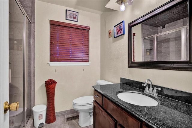 bathroom featuring vanity, toilet, walk in shower, and tile patterned flooring