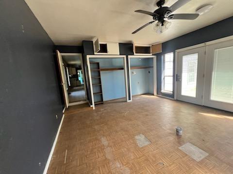 interior space with ceiling fan, access to exterior, and light parquet floors