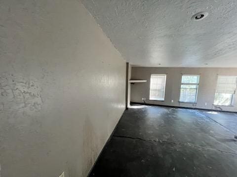 empty room featuring a textured ceiling and concrete floors