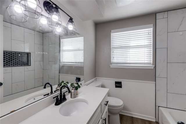 bathroom with hardwood / wood-style flooring, toilet, and vanity