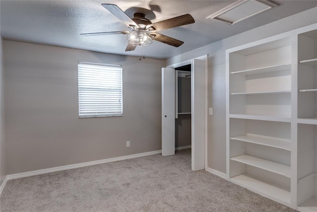 unfurnished bedroom featuring ceiling fan, a textured ceiling, and light carpet