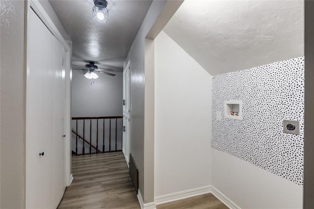 corridor featuring wood-type flooring and a textured ceiling