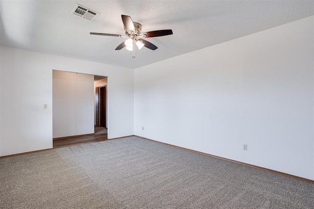 spare room with visible vents, a textured ceiling, carpet, baseboards, and ceiling fan