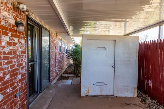 view of patio featuring a storage shed, an outdoor structure, and fence