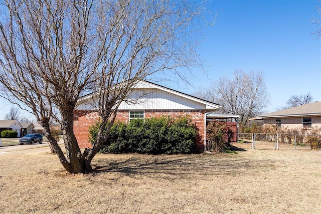 view of home's exterior with brick siding and fence