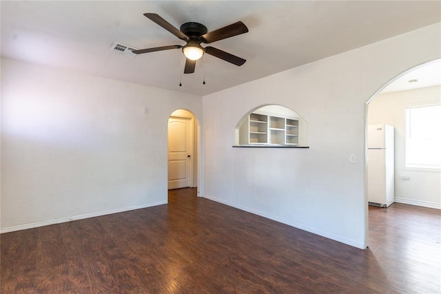 empty room featuring ceiling fan and dark hardwood / wood-style flooring