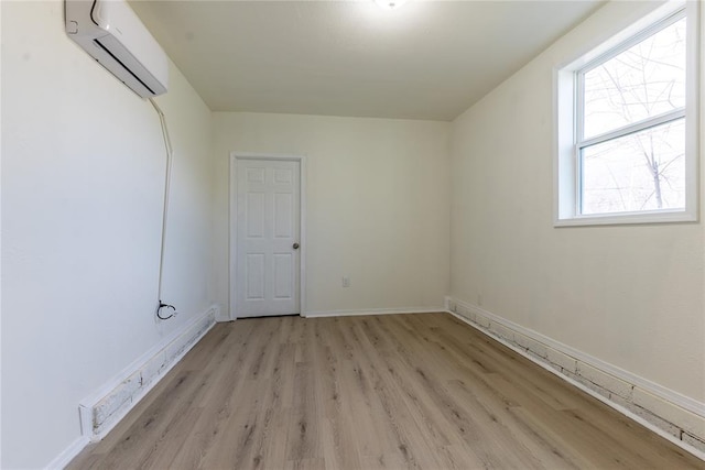 spare room featuring light hardwood / wood-style floors and a wall mounted air conditioner