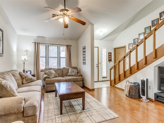 living room with ceiling fan, light hardwood / wood-style flooring, and vaulted ceiling