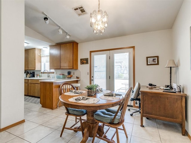 tiled dining space with a notable chandelier and sink