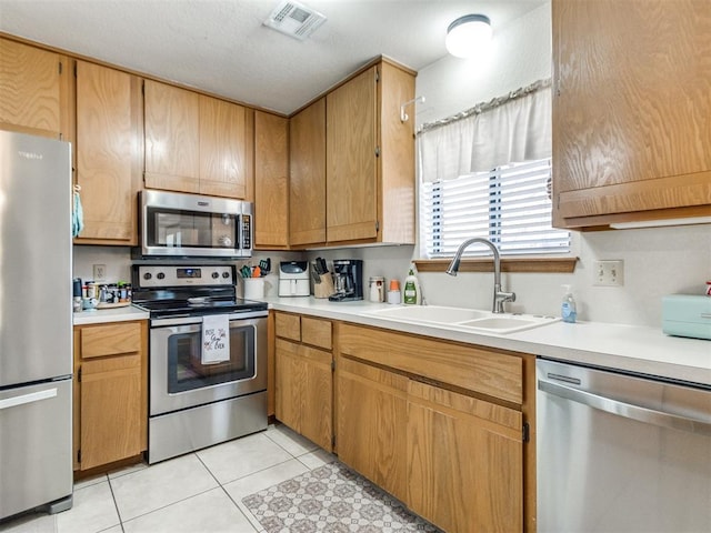 kitchen featuring sink, stainless steel appliances, and light tile patterned flooring