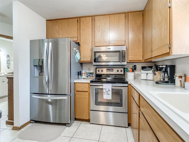 kitchen featuring sink, light tile patterned floors, and stainless steel appliances