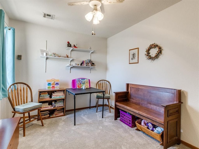 living area with light carpet and ceiling fan