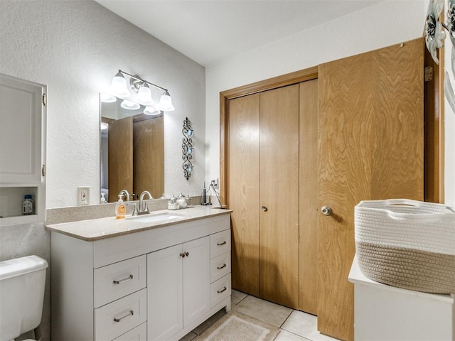 bathroom with vanity, toilet, and tile patterned floors