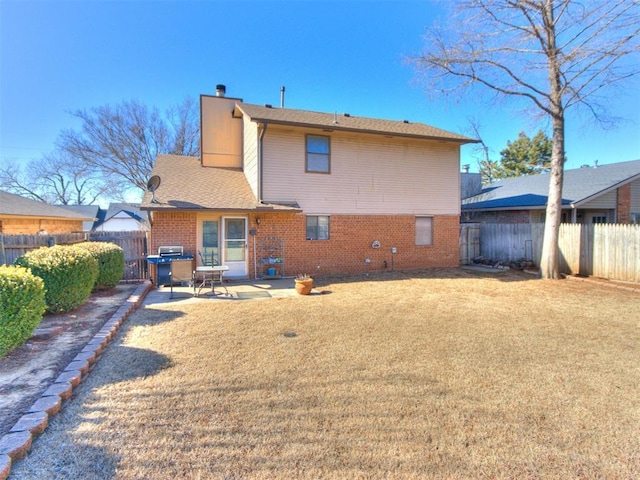 rear view of house featuring a lawn and a patio