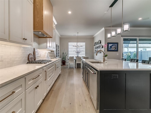 kitchen with white cabinetry, pendant lighting, sink, and a center island with sink