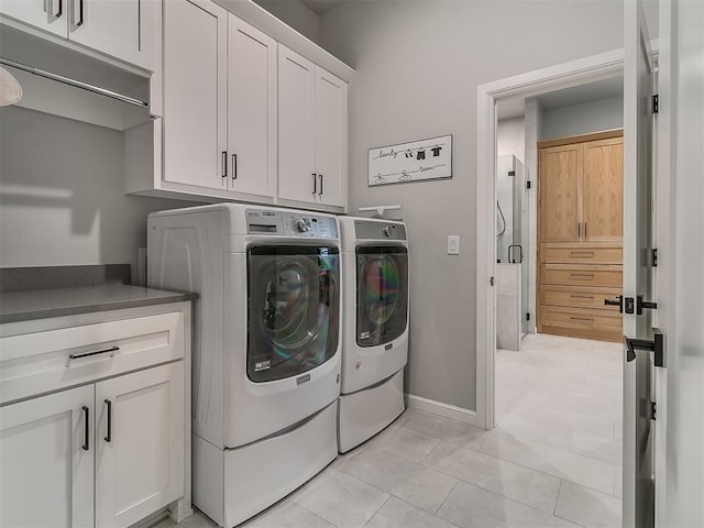 washroom with independent washer and dryer, cabinets, and light tile patterned flooring