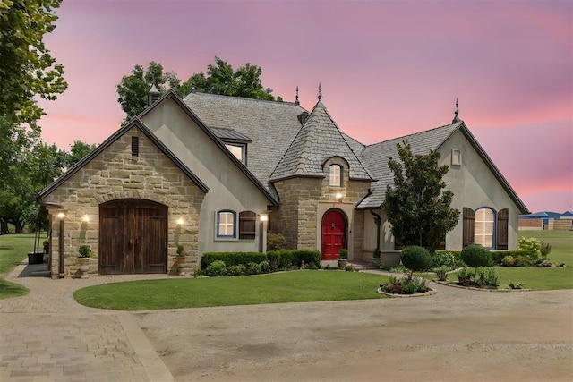 french provincial home with a lawn