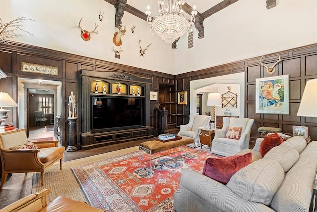 living room featuring a notable chandelier, a high ceiling, and wooden walls