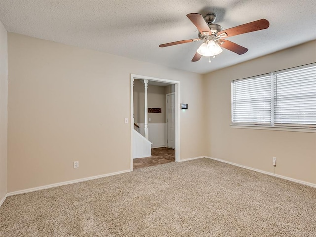 carpeted empty room featuring a textured ceiling and ceiling fan