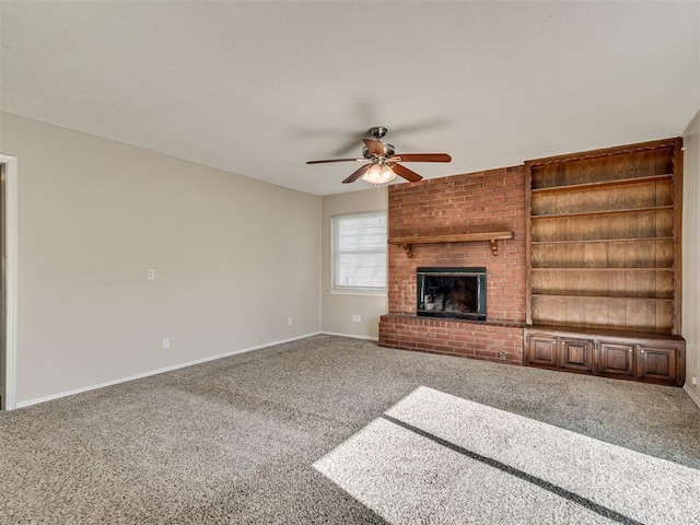 unfurnished living room featuring built in shelves, ceiling fan, carpet flooring, and a brick fireplace