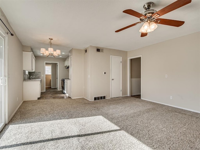 interior space featuring ceiling fan with notable chandelier, sink, and carpet