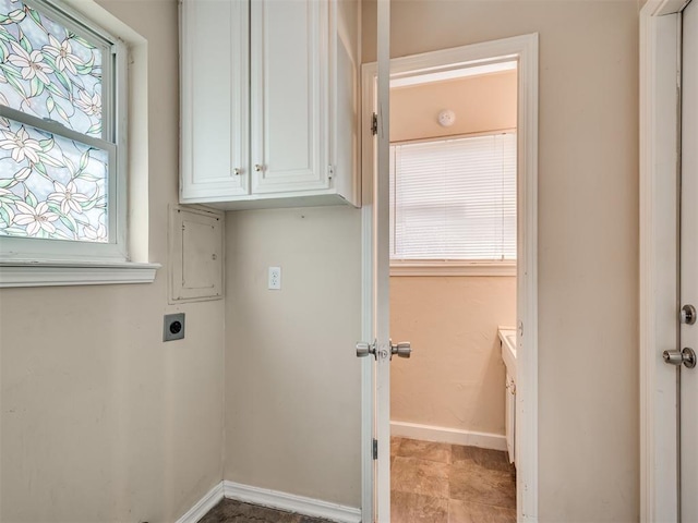 laundry room with cabinets, electric dryer hookup, and a healthy amount of sunlight