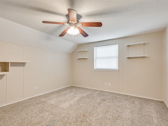 additional living space featuring ceiling fan, lofted ceiling, carpet flooring, and a textured ceiling