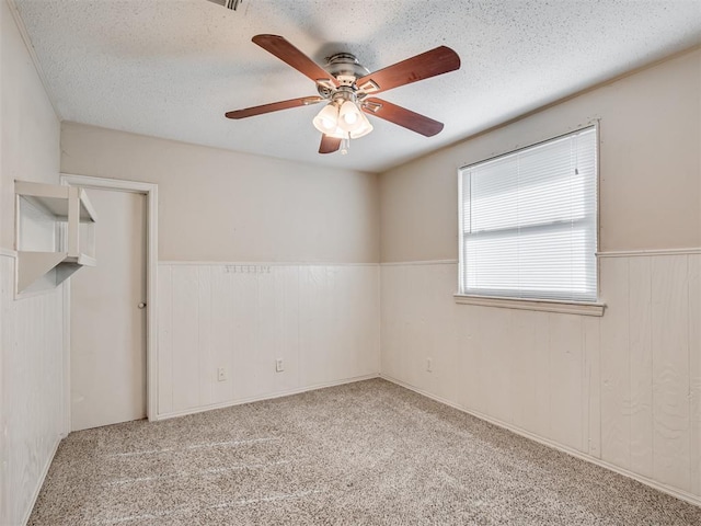 carpeted spare room featuring ceiling fan and a textured ceiling