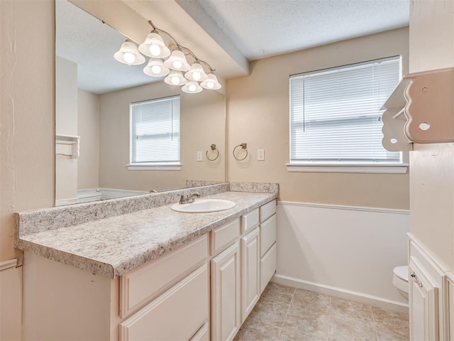 bathroom featuring vanity, plenty of natural light, and toilet