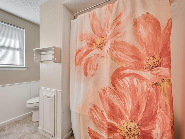 bathroom with toilet and a textured ceiling