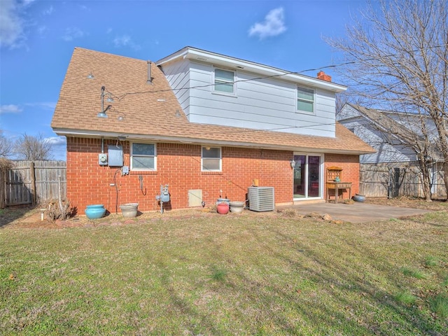 rear view of house featuring a patio, a yard, and central AC