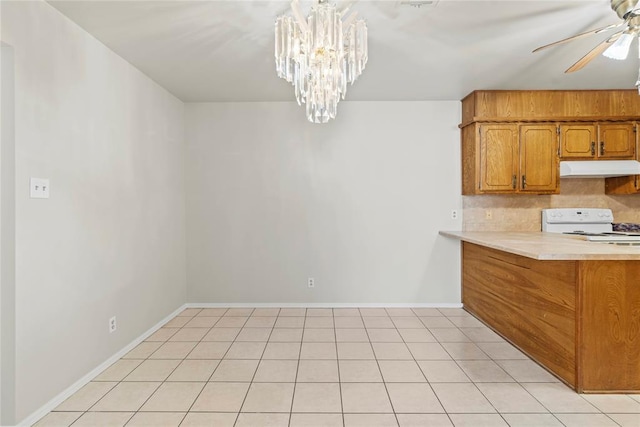 kitchen with light tile patterned flooring, white electric range, ceiling fan with notable chandelier, and decorative backsplash