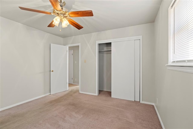 unfurnished bedroom with ceiling fan, a closet, and light carpet