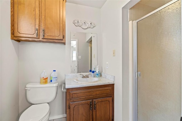 bathroom featuring vanity, toilet, and a shower with door