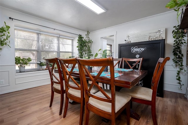 dining area featuring hardwood / wood-style floors and crown molding