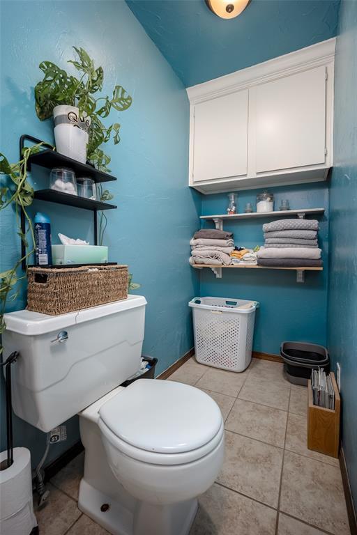 bathroom with toilet and tile patterned flooring