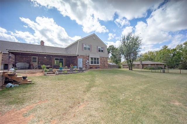 rear view of property featuring a lawn