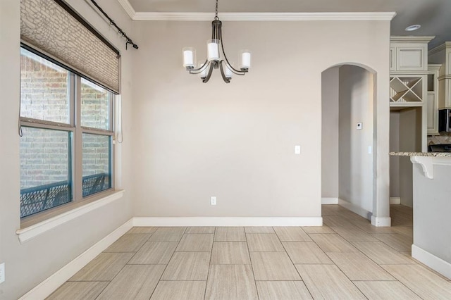 unfurnished dining area featuring crown molding and a chandelier