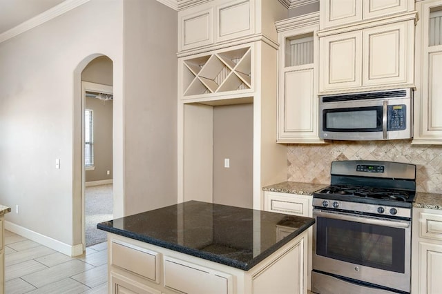 kitchen featuring ornamental molding, appliances with stainless steel finishes, and cream cabinetry