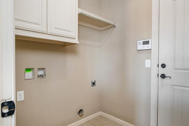 washroom with cabinets, hookup for a washing machine, and hookup for an electric dryer